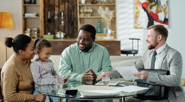 Group,Of,Cheerful,Ethnic,Couple,With,Daughter,And,Adult,Bearded Group of cheerful ethnic couple with daughter and adult bearded agent gathering at table to discuss real estate mortgage