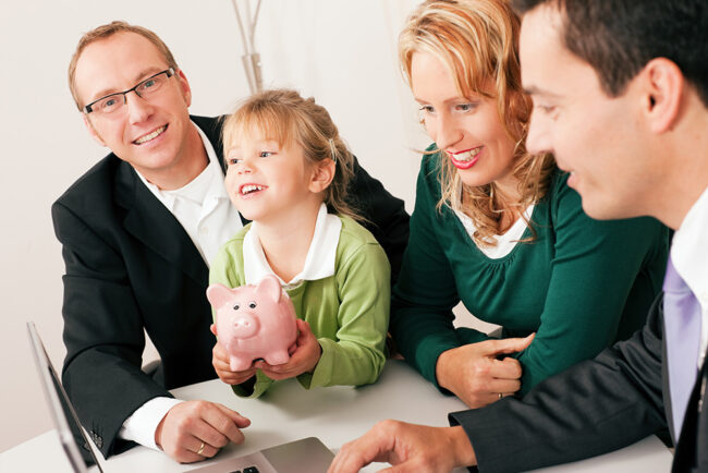 Family with their consultant (assets, money or similar) doing some financial planning - symbolized by a piggy bank the daughter is holding in her hand