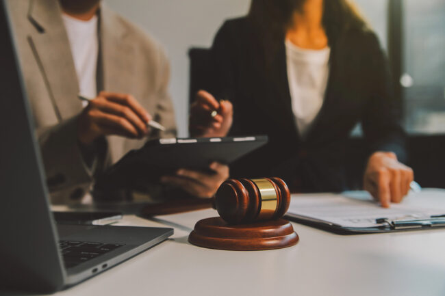 Lawyer, legal advisor, businessman brainstorming information on agreement details Business contracts in legal processing books for accuracy in contract documents. joint financial investment.