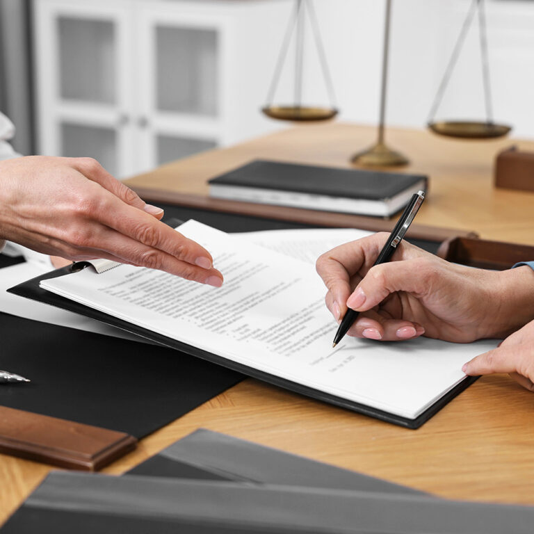 Senior woman signing document in lawyer's office, closeup